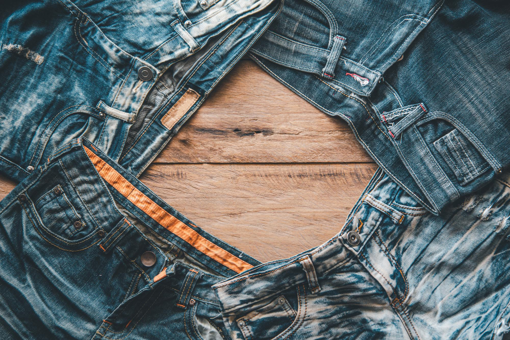 denim jeans are placed on the wooden floor.